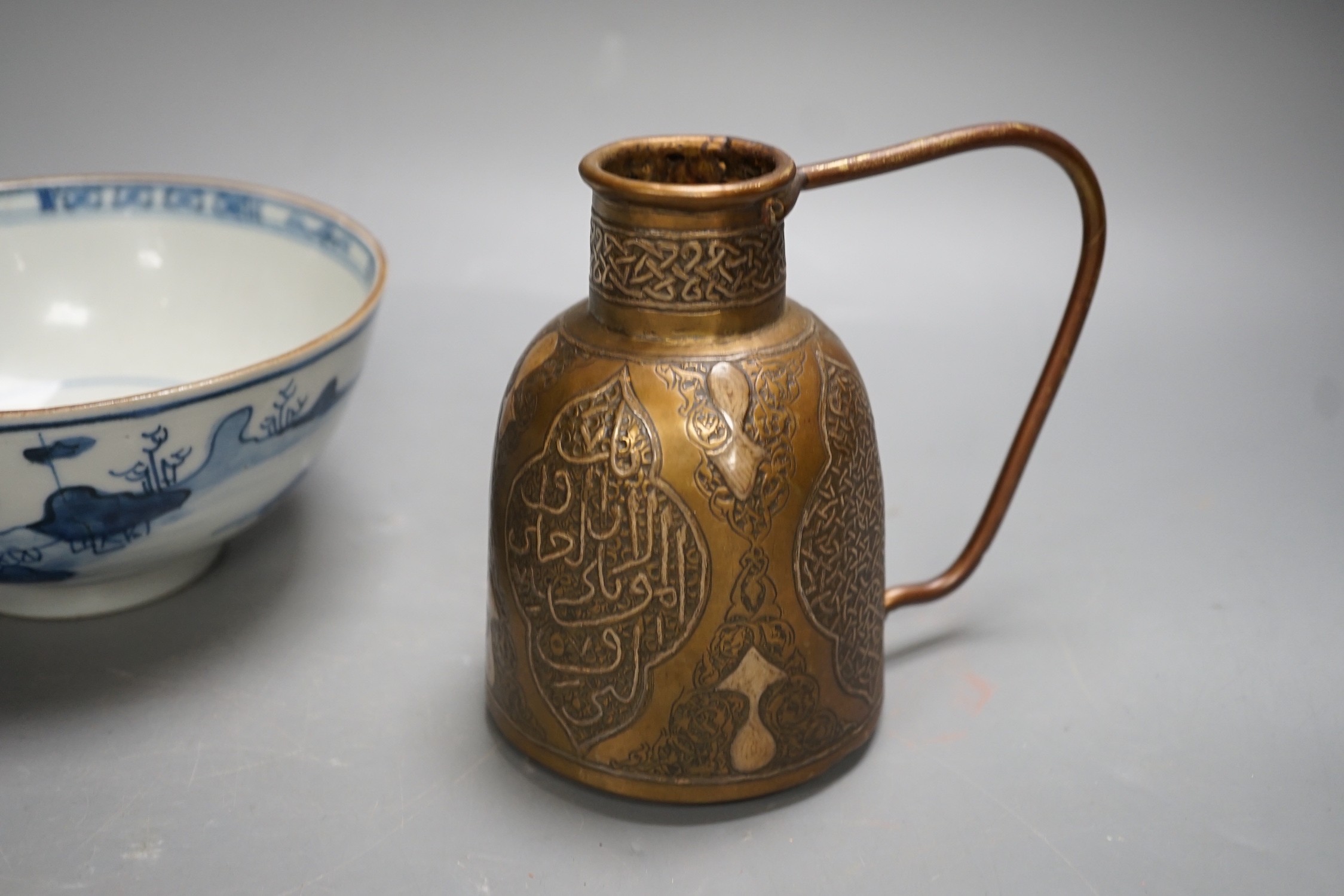 A Chinese Ming dynasty internally decorated porcelain tea bowl, an 18th century blue and white bowl, two other blue and white bowls, a similar water pot and an Islamic brass vessel